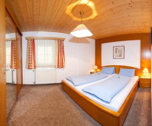 1 dormitorio con 1 cama grande y techo de madera en der Steinerwirt, en Wagrain
