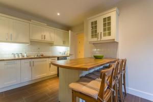 cocina con armarios blancos y encimera de madera en The Artane Self Catering, en Dublín