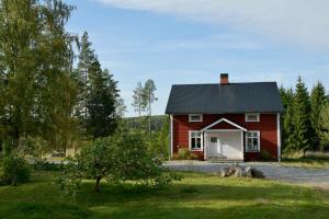 a red barn with two dogs in front of it at Torpet i Sjö in Nyland