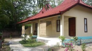 una pequeña casa con techo rojo en Serah's Homestay en Kuta Lombok