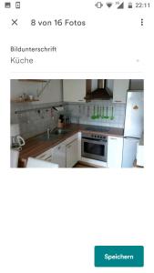 a kitchen with white cabinets and a white refrigerator at Fewo Hilde in Annenheim