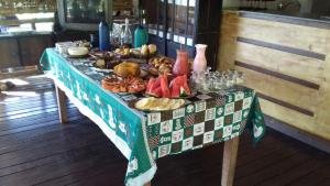 stół z tkaniną stołową z jedzeniem w obiekcie Pousada Estância Macaúbas - w mieście São Roque de Minas