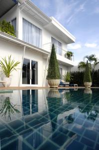 a swimming pool in front of a house at Phuket Boat Quay in Panwa Beach