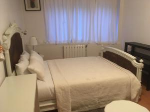 a bedroom with a white bed and a window at Villa Cemaste in Montpellier