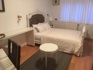 a bedroom with a bed and a table and a stool at Villa Cemaste in Montpellier