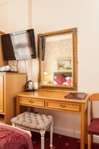 a mirror on a dresser in a hotel room at Roseview Alexandra Palace Hotel in London