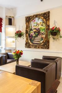 a painting hanging on a wall with a table and chairs at Roseview Alexandra Palace Hotel in London