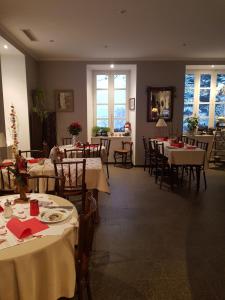 un comedor con mesas, sillas y ventanas en Le Domaine De Pairis, en Orbey