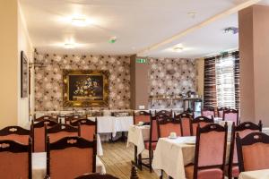 a restaurant with tables and chairs and a painting on the wall at Roseview Alexandra Palace Hotel in London