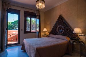 sypialnia z dużym łóżkiem i balkonem w obiekcie Hotel Coral Playa w mieście Chiclana de la Frontera +37 zdjęć