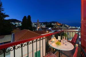 a balcony with a table with wine glasses on it at Castello Venetsiana in Symi