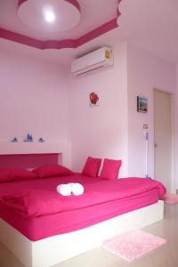 ein Schlafzimmer mit einem roten Bett mit roten Kissen in der Unterkunft Baan Kaneang in Ko Larn