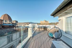 a balcony with a rattan chair on a roof at Bsl Boutique Suite in Florence