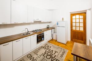 リヴィウにあるThree-room apartmentの白いキャビネットと床の看板付きのキッチン