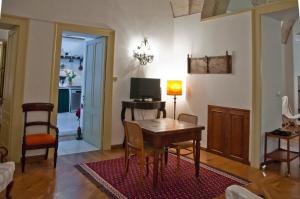 a living room with a table and a television at Garden Suite at Palazzo Famularo in Lecce