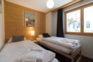 ヴェンゲンにあるChalet Brunner 3のベッド2台と窓が備わる客室です。