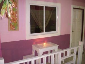 Zimmer mit einem Fenster und einem Tisch mit einer Kerze in der Unterkunft Baan Kaneang in Ko Larn + 15 Fotos