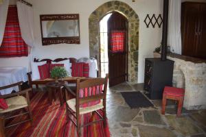 een woonkamer met een tafel en een houtkachel bij Anna's Stone House in Megála Khoráfia