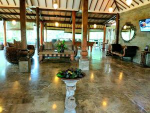 a large lobby with a table in the middle of a room at Gajah Mina Beach Resort in Selemadeg