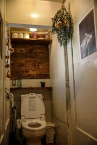 a small bathroom with a toilet and a plant at Dot Hostel Nagano in Nagano