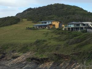 a house sitting on top of a grassy hill at OceanScape Luxury Beachfront Villas in Scotts Head