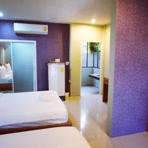 a room with a bed and a refrigerator at The Rhea in Udon Thani