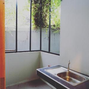 baño con lavabo y ventana en The Rhea, en Udon Thani