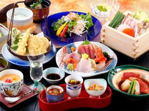 stół z talerzami żywności i miskami żywności w obiekcie Hotel Izukyu w mieście Shimoda
