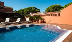 basen na patio z krzesłami i drzewami w obiekcie Hotel Coral Playa w mieście Chiclana de la Frontera