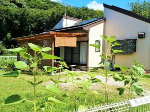 una pequeña casa con un jardín frente a ella en Kitchen Garden en Tateyama