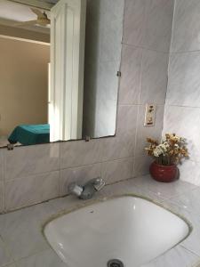 lavabo con espejo y bañera en Linda Casa Acogedora, en Tarija