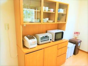 uma cozinha com um micro-ondas e uma torradeira num armário em Kitchen Garden em Tateyama