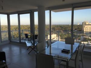 a dining room with a glass table and chairs at Bellagio Tower New Apartments in Punta del Este