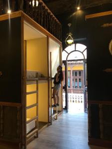 a woman standing in a room with bunk beds at The Clock Hostel & Suites in Cartagena de Indias
