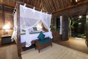 a bedroom with a canopy bed in a room at Honeymoon Green Villa in Ubud +104 photos
