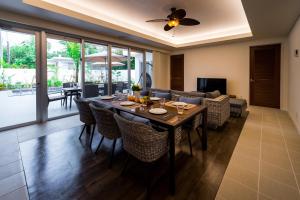 comedor y sala de estar con mesa y sillas en Coldio Pool & Villas Sumuide en Nago