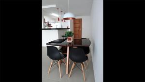 una cocina con mesa negra y sillas negras en Le Bon Vivant 307 B en Arraial do Cabo