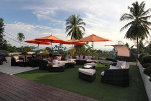 a patio with couches and tables and umbrellas at Baan Seaview Holiday Villas in Lamai