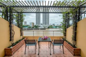 a balcony with a table and two chairs and a view at New Siam Riverside - SHA Certified in Bangkok