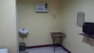 a small bathroom with a sink and a air conditioner at RMS Travellers Inn in Camotes Islands