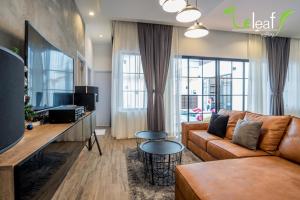 a living room with a couch and a tv at J Pool Villa Huahin in Hua Hin