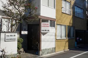 un bâtiment avec un panneau indiquant l'ambassadeur romain dans l'établissement Ryokan Katsutaro, à Tokyo