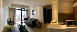 a living room with a couch and a kitchen at Portovita Towers in Manila