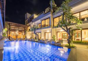 スミニャックにあるMokko Suite Villas Umalas Baliの夜間の建物前のスイミングプール