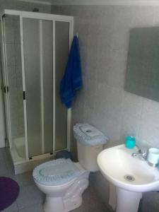 a bathroom with a white toilet and a sink at Hospedaje Los Tatis in Villarrica