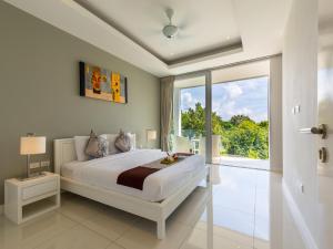een slaapkamer met een groot bed en een groot raam bij Horizon Residence Rentals in Choeng Mon Beach