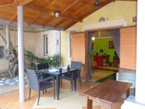 een patio met een tafel en stoelen en een eetkamer bij Cocoville in Pasikuda