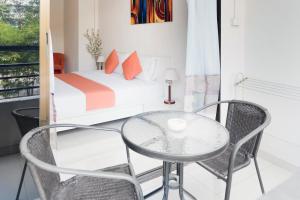 a room with a bed and a glass table and chairs at Sunny Beach Residence in Jomtien Beach