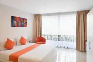 um quarto de hotel com uma cama e uma janela em Sunny Beach Residence em Praia de Jomtien