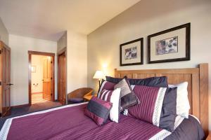 CO405 Copper One Lodge Condo في كوبر ماونتين: غرفة نوم مع سرير بملاءات ووسائد أرجوانية
